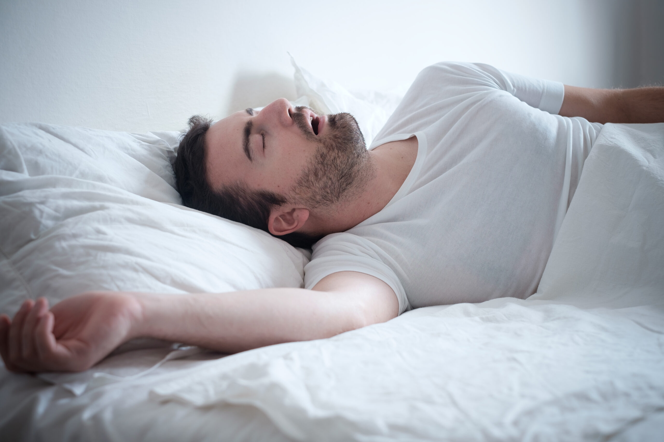 man lying in bed snoring in sleep, how to stop snoring