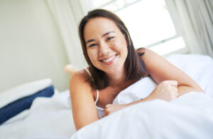 woman waking up smiling in bed, Airway-Focused Dentistry